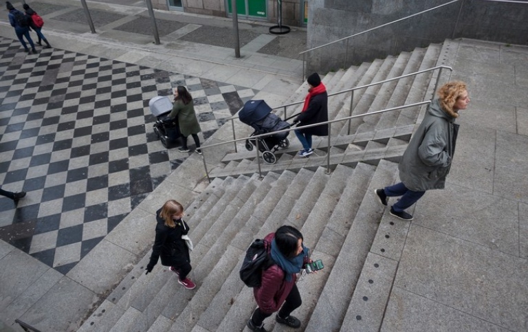 Människor i stadsmiljö som går i en trappa.